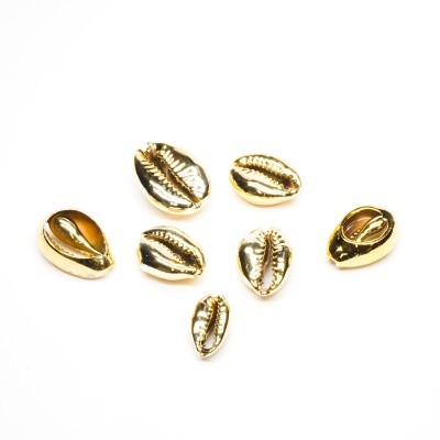 Contas douradas em forma de conchas marinhas sobre fundo branco