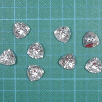 Botões transparentes em forma de coração sobre superfície quadriculada verde