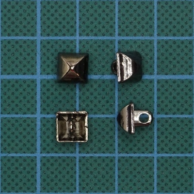 Peças metálicas pequenas prateadas sobre superfície azul quadriculada