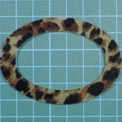 Elástico de cabelo oval padrão leopardo sobre superfície azul com grelha