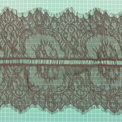 Renda castanha escura com padrão floral sobre fundo verde com quadrícula