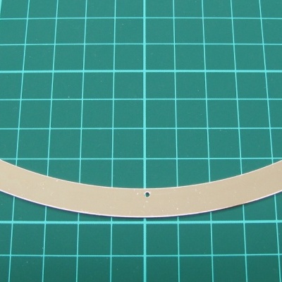 Faixa branca com furos sobre superfície de grelha verde