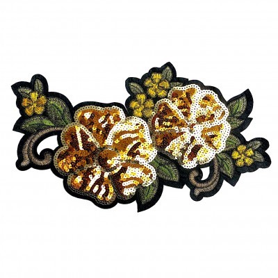 Aplicação de tecido bordada com flores amarelas e douradas e folhas verdes