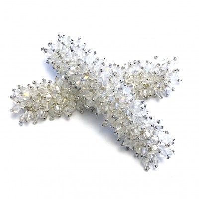 Acessório de cruz com pedras transparentes e prateadas sobre fundo branco