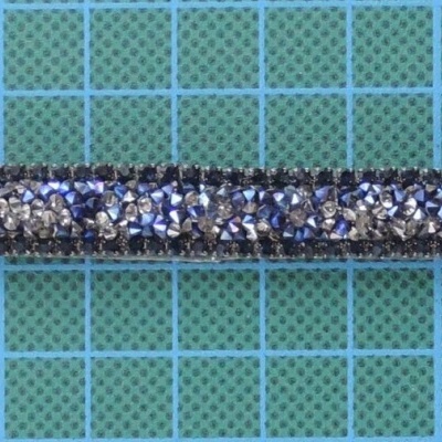 Cordão fino com glitter prateado e preto sobre superfície quadriculada azul