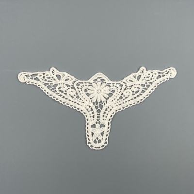 Aplicação em renda branca com padrão floral sobre fundo cinza