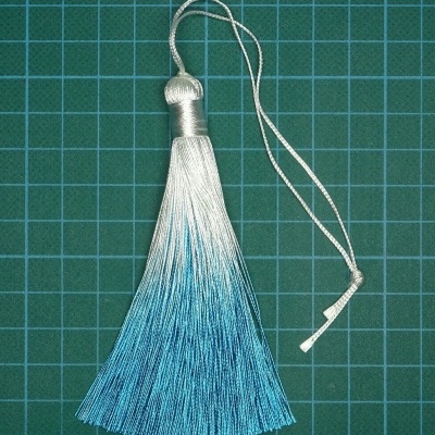 Tassel branco e azul em fundo verde quadriculado