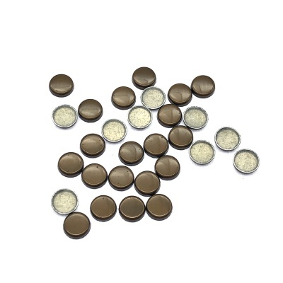 Pequenos botões castanhos com parte metálica e interior branco peludo em fundo branco