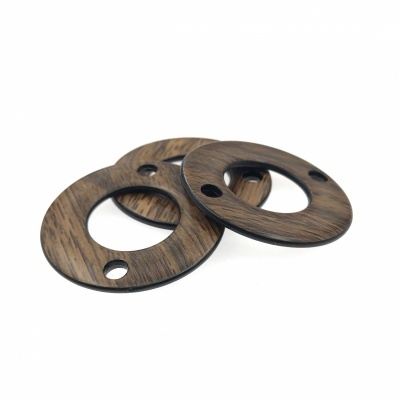 Duas rosetas redondas de madeira escura com furos