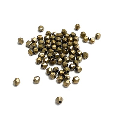 Contas metálicas douradas facetadas com buraco no centro, sobre fundo branco