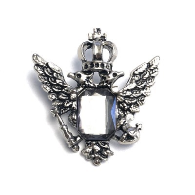 Broche prateado em forma de águia bicéfala com pedra central transparente