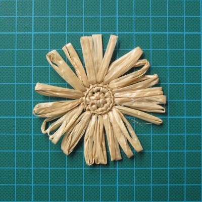 Flor artesanal de palha sobre base de corte verde de grid