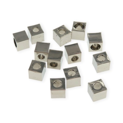 Conjunto de cubos metálicos prateados com orifício central sobre fundo branco