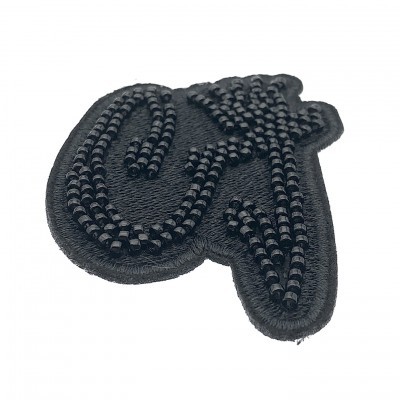 Patch bordado preto com contas pretas em fundo branco