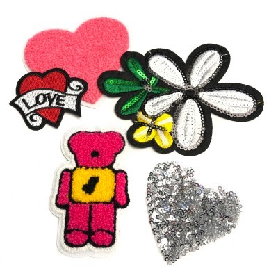 Conjunto de aplicações decorativas em tecido e lantejoulas em formato de coração, flor, folha e urso