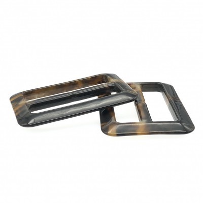 Duas fivelas retangulares marmoreadas em castanho e preto sobre fundo branco