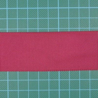 Fita vermelha em tecido sobre fundo quadriculado verde