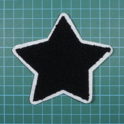 Patch em forma de estrela preta com borda branca sobre fundo verde quadriculado