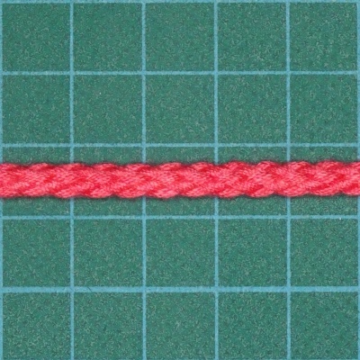 Cordão vermelho trançado sobre fundo verde com grelha azul
