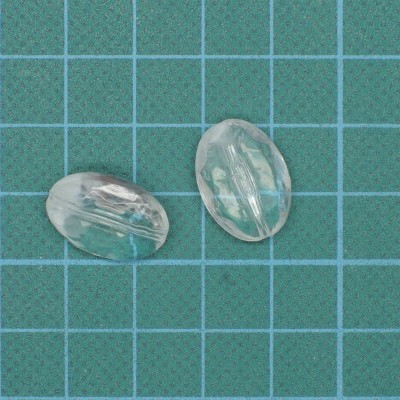 Dois objetos transparentes ovais com metal interno sobre fundo quadriculado azul.