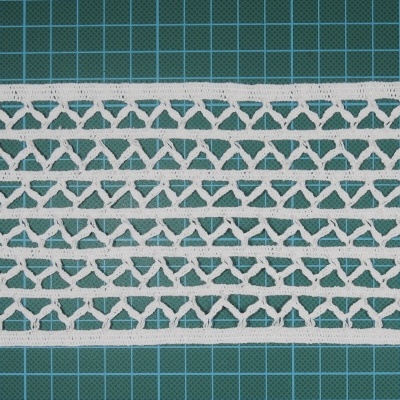 Tira de renda branca com padrão triangular sobre fundo verde de corte
