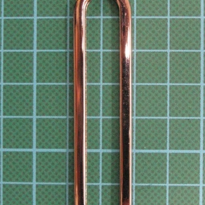 Clips de papel metálico cobre sobre fundo quadriculado verde