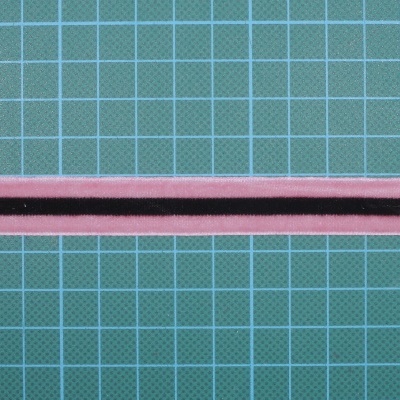 Fita têxtil rosa com linha preta sobre fundo quadriculado azul e branco.