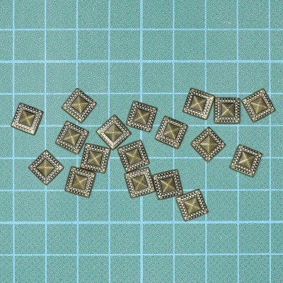 Tachas quadradas metálicas douradas com superfície azul quadriculada