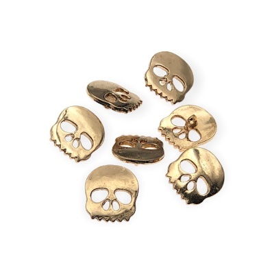 Seis contas metálicas douradas em forma de caveira