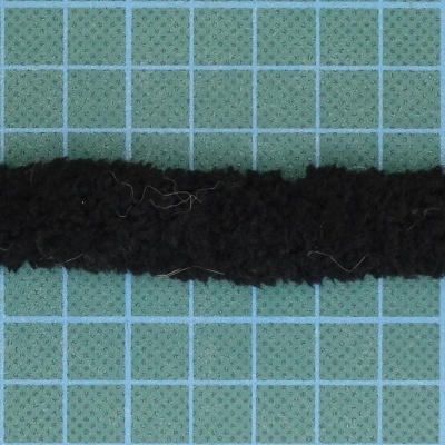 Faixa de tecido preta felpuda sobre superfície quadriculada azul