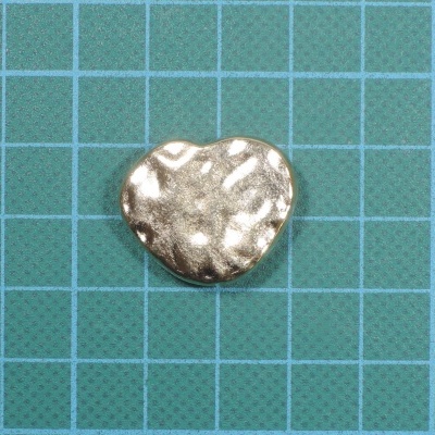 coração metálico prateado com textura sobre fundo azul quadriculado