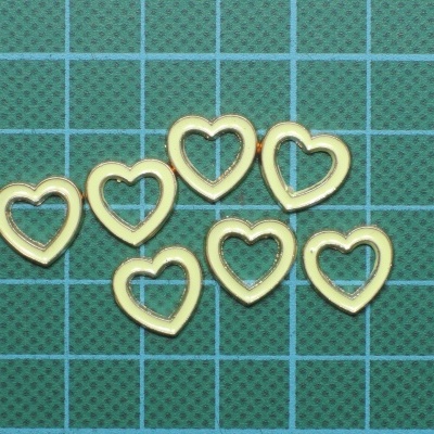 Sete argolas douradas em forma de coração sobre base verde com grelha