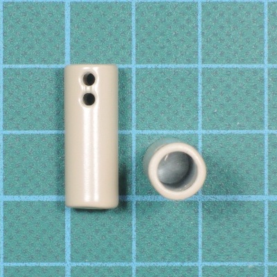 Peças cilíndrica e anelar brancas sobre superfície quadriculada azul