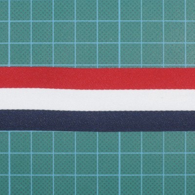 Tiras de tecido vermelho, branco e azul escuro sobre superfície verde quadriculada