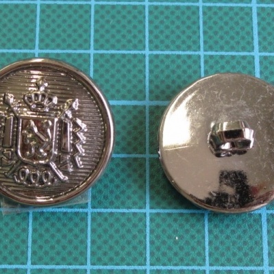 Dois botões metálicos prateados com brasão e presilha