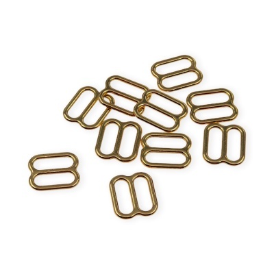 Pequenas fivelas metálicas douradas sobre fundo branco