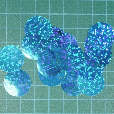 Lantejoulas azuis brilhantes sobre superfície quadriculada verde