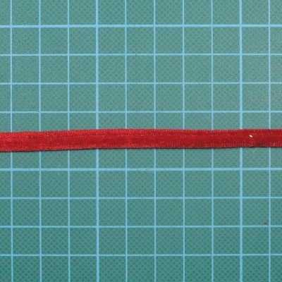 Fita vermelha aveludada sobre fundo quadriculado verde