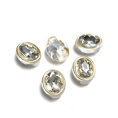 Botões ovais com pedra transparente e borda metálica dourada