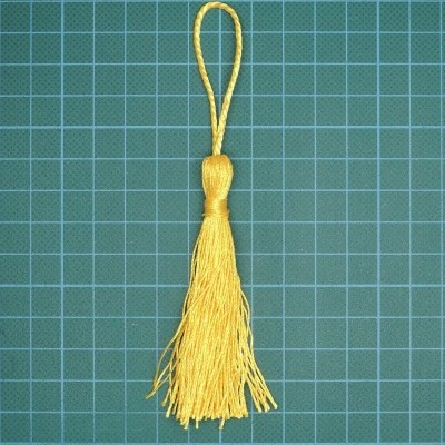 Raspadinha amarela com laço sobre superfície quadriculada verde