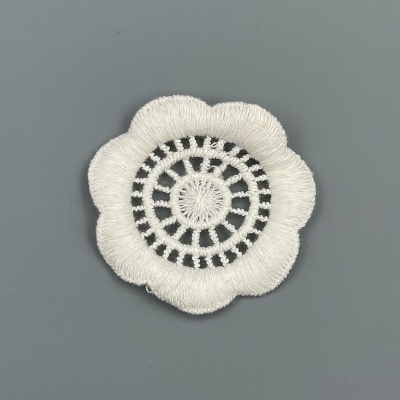Aplicação de tecido branca em forma de flor com padrão circular em macramê