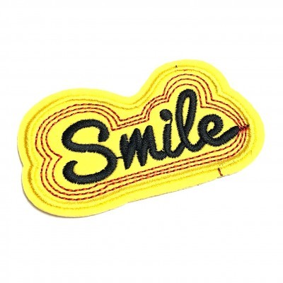 Patch bordado amarelo com a palavra Smile em preto