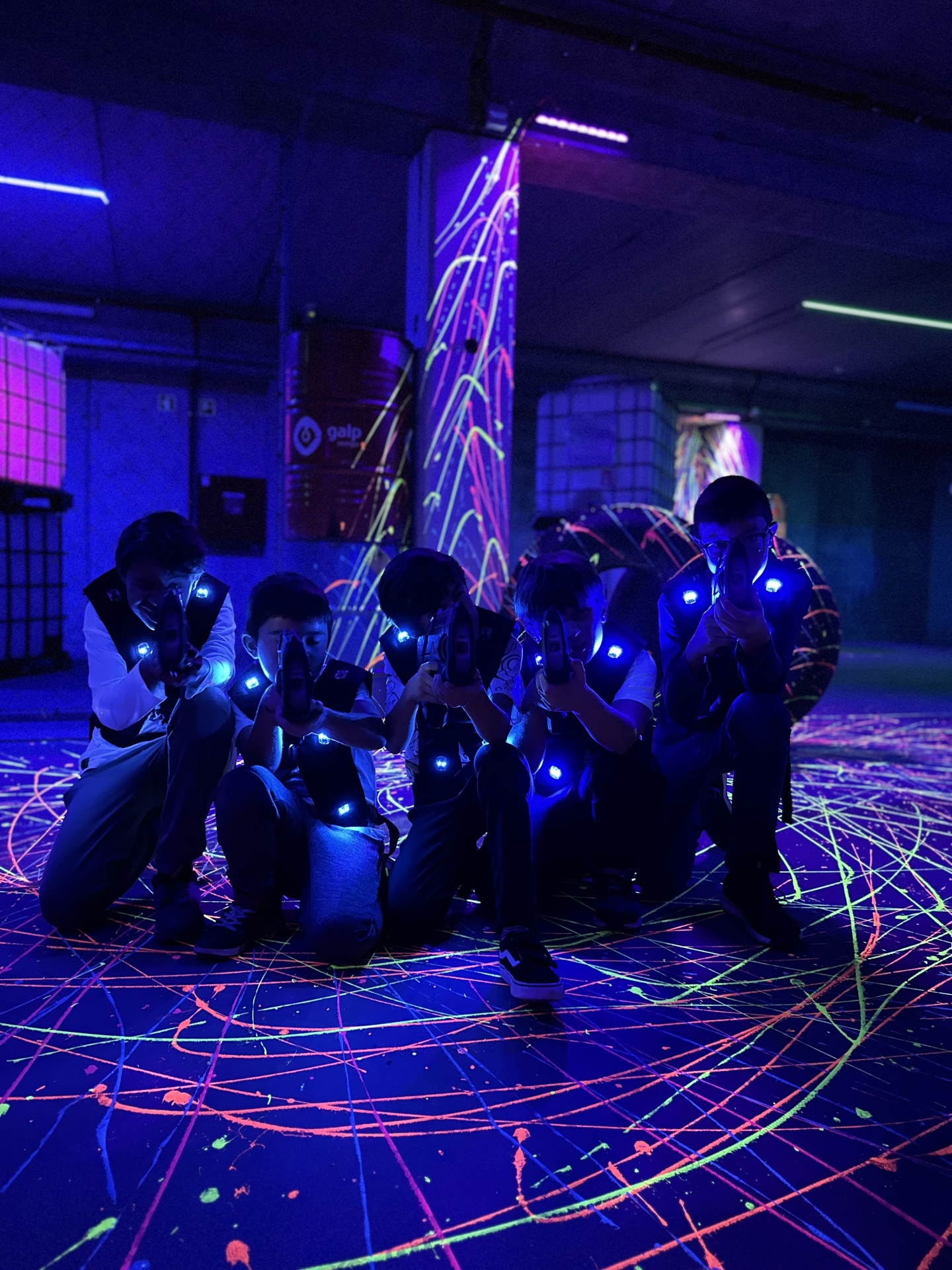 Gift Voucher - Xtreme Laser Tag, Sintra | 5 pessoas Cinco pessoas com coletes e armas de laser num espaço com iluminação neon