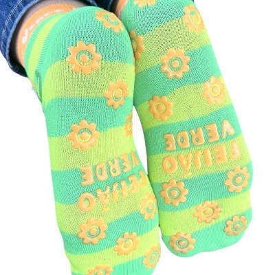 Meias antiderrapantes verde e amarelo com flores e texto na sola