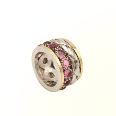 Anel largo em metal com detalhes dourados e pedras rosas decorativas