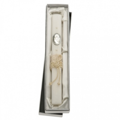 Vela branca decorativa com fita cremosa e medalhão prateado numa caixa com forro branco