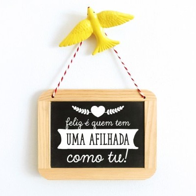 Quadro decorativo com frase em português pendurado por corda e pássaro amarelo