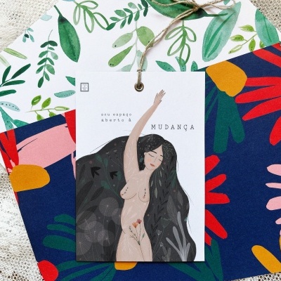 Cartões coloridos com padrões florais e cartão central com ilustração de mulher e texto pendurados