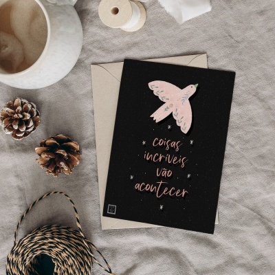 Cartão com pássaro e texto sobre tecido com elementos de decoração e café