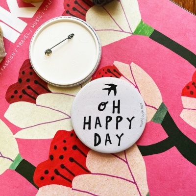 Dois botões redondos sobre revista colorida com flores e pedras